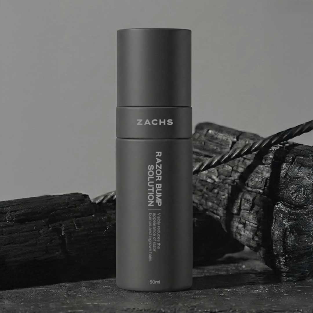 ZACHS Razor Bump Solution, a matte 50 ml bottle on charcoal wood